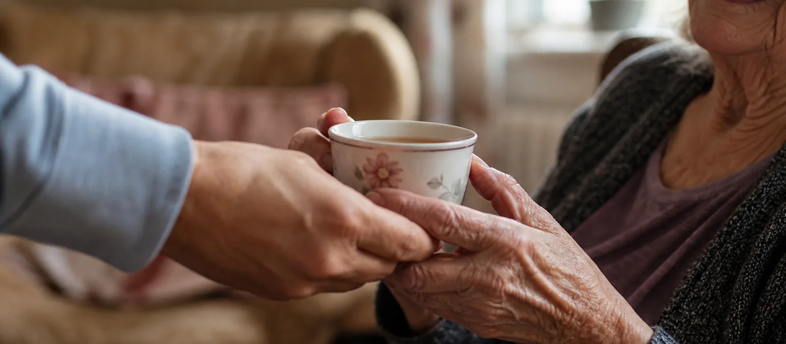 Einsamkeit im Alter: Was wirklich hilft | Sonnenseite Alltagshilfen Junge und alte Hand reichen einander eine Tasse Tee – Symbol für Nähe und gegen Einsamkeit im Alter.
